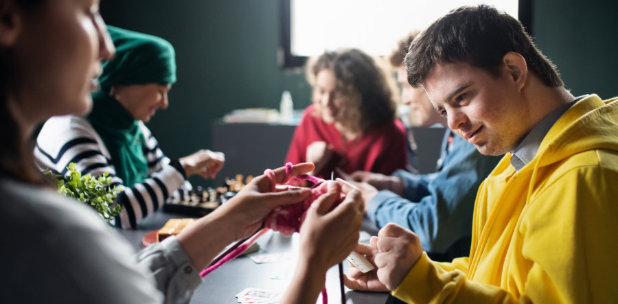 group of people playing cards and board games in community center