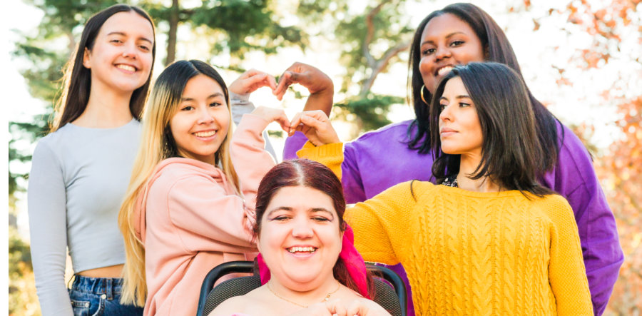 group of women making heart-shaped hands outdoors