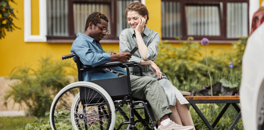man in wheelchair with woman outside